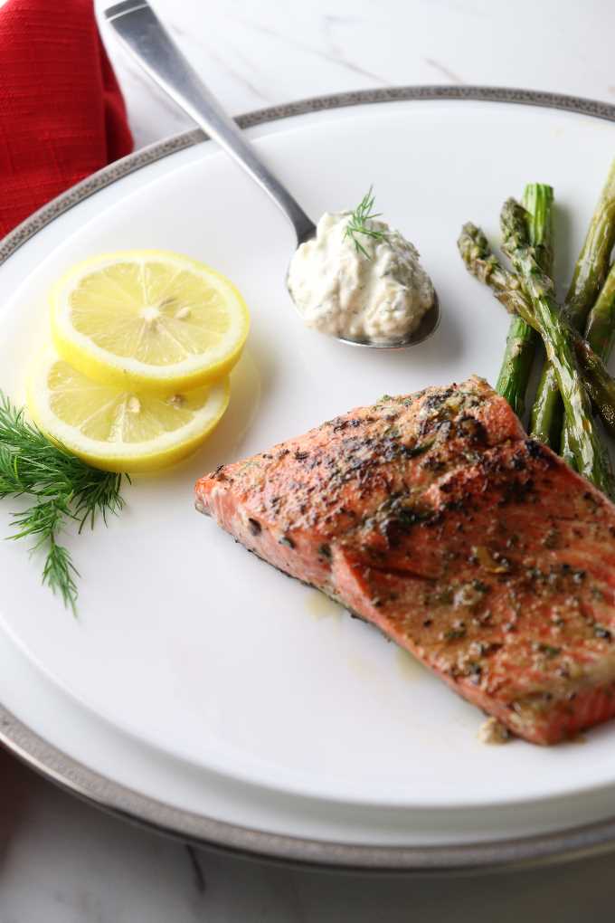 cooked salmon on a plate with lemon slices and asparagus