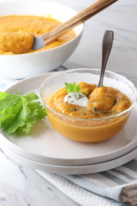 slow cooker butternut squash soup with a dollop of sour cream in a bowl